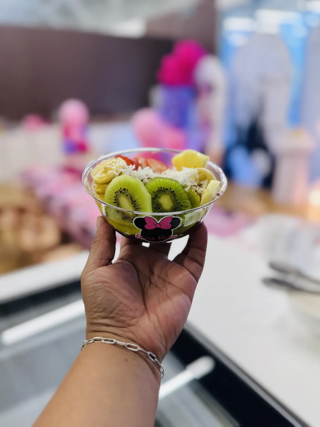 Handheld fruit bowl with kiwi and fresh toppings at a Blush Fizz Co. daytime event