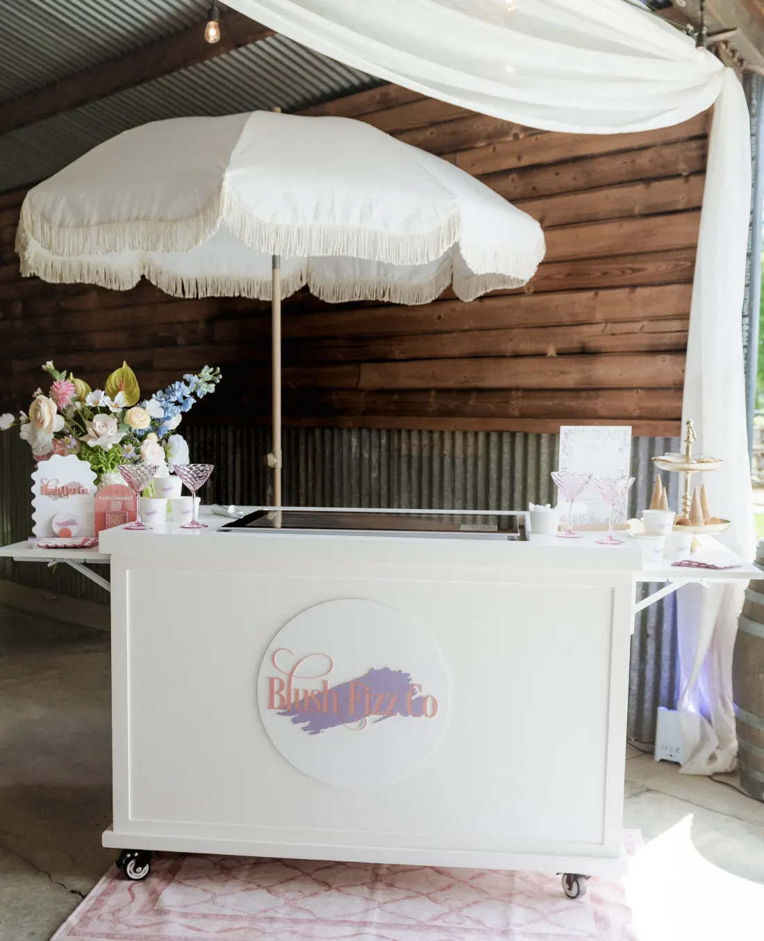 Blush Fizz Co. gelato cart display with a white umbrella and branded signage